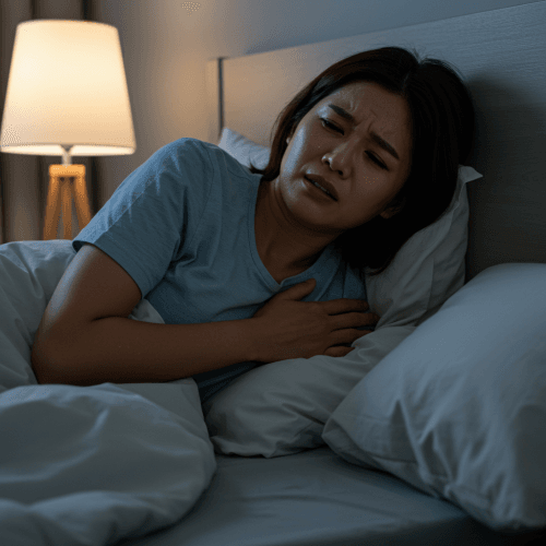 심근경색, 전조 증상부터 응급 대처법까지 총정리 2 한 여성이 침대에 누워 잠결에 갑자기 가슴을 부여잡고 힘들어하는 모습